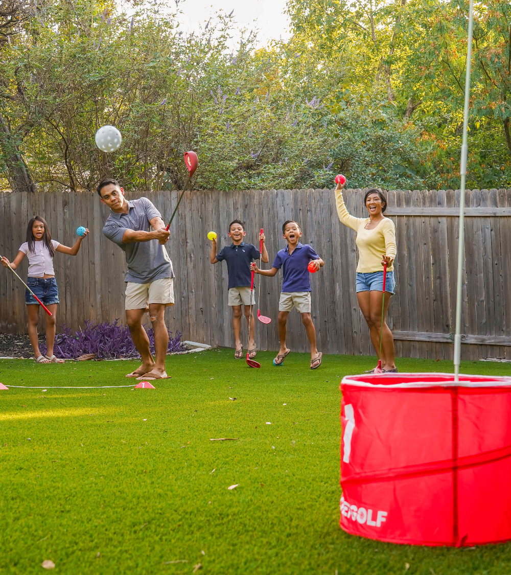 Friends playing BucketGolf in a backyard